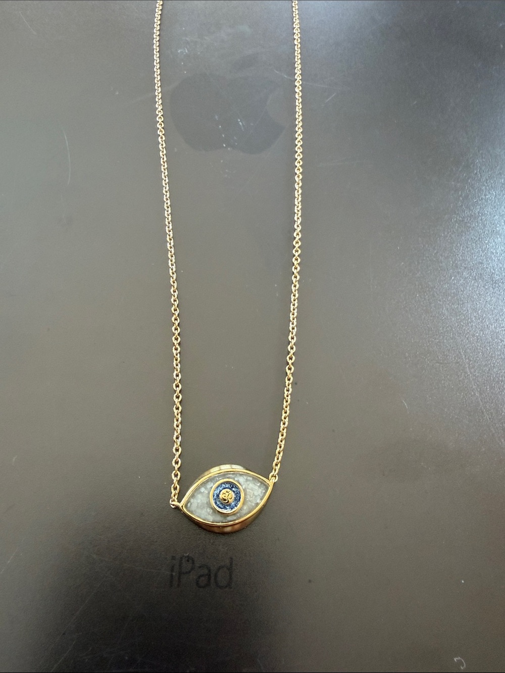 Gold toned evil eye sand filled
necklace